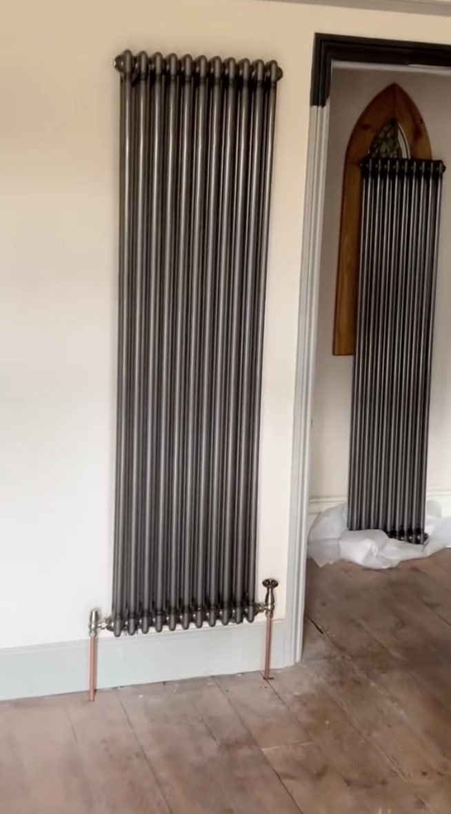 Two tall anthracite column radiators fitted in a period room