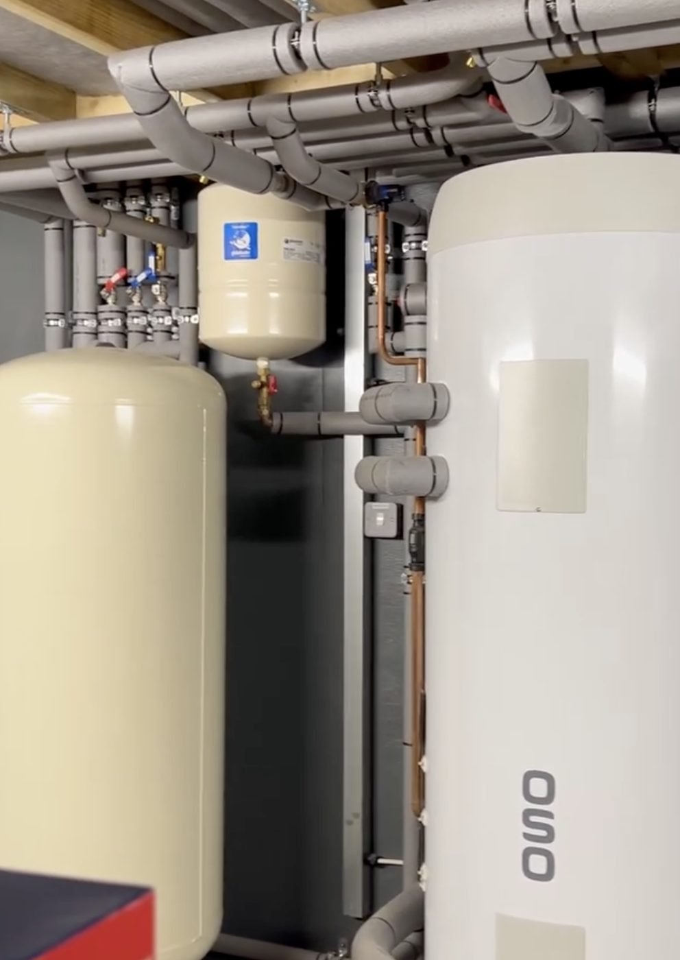 Plant room with an OSO hot water cylinder, buffer vessel and insulated pipework
